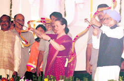 PM Manmohan Singh and Congress president Sonia Gandhi with bows and arrows ahead of burning of an effigy of Ravana on the occasion of Dasehra in New Delhi 