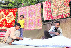 As winter knocks on the door, a roadside worker is busy stitching quilts in Karnal 