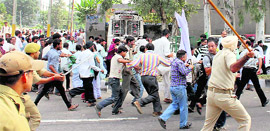 Policemen disperse PDP workers protesting against the Chief Minister in Jammu. 
