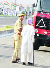 A policeman helps an old man cross a road in Jammu. 