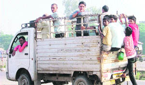 A teenager boards a moving pick-up van while risking his life near Jalandhar bypass in Ludhiana.