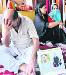 Riaz Malik, father of Wasim Akhtar Malik, tries to control his emotions at his house at Bathindi in Jammu on Saturday. Wasims sister (face covered) and maternal aunt are also seen. 