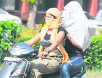 Girls cover their faces to protect themselves from pollution in Ludhiana. 