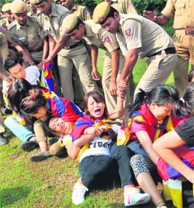 Tibetan students hold on to each other as they are detained by the police outside the Chinese Embassy in New Delhi on Sunday