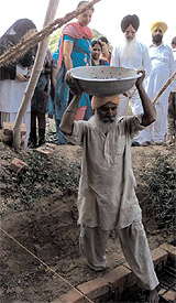 A poor daily wager, Baldev Singh, laying the foundation stone of the prestigious Baba Farid Kindergarten in Faridkot on Monday.