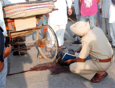 A policeman examines the spot where a rickshaw-puller was murdered in the wee hours on Monday in the Vishal Nagar locality near the Santpura road.