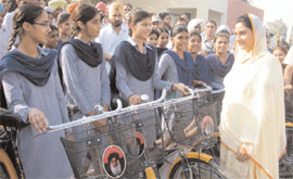 Bathinda MP Harsimrat Kaur Badal distributing bicycles to the girl students on the premises of the Government High School at Nehianwala village on Monday.