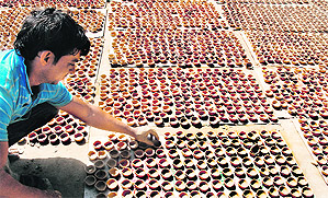 A potter prepares traditional earthern lamps for Diwali in Chandigarh on Monday.