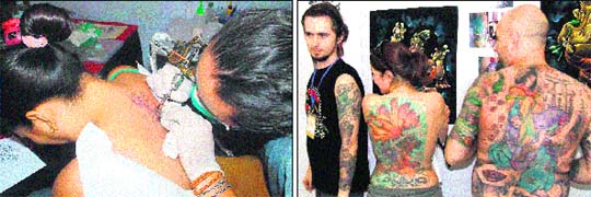 An artist draws a tattoo on the back of a girl; and participants display their tattoos at International Tattoo Show in Faridabad. 