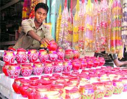 A boy displays decorated earthern pots used in Karva Chauth rituals in Ludhiana