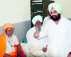 Congress MLA Sukhbir Singh Sarkaria with one of the injured Congress worker at Guru Nanak Dev Hospital in Amritsar on Wednesday