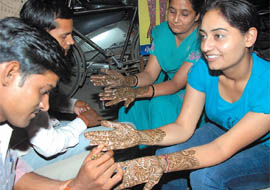 Girls getting their hands decorated with henna ahead of Karva Chauth at Dhobi Bazaar in Bathinda on Wednesday. 