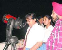 Students watch moon and jupiter through an electronic telescope at KVM School in  Ludhiana 