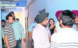 Students of the Commerce and Business Management Department wait outside the heads office in the Guru Nanak Dev University Complex on Thursday. 