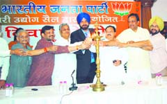 Local and state-level BJP leaders including city MP Navjot Sidhu pose for a picture while either actually or pretending to reach out to the lamp on Thursday.