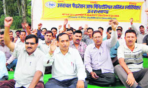 Ministerial services employees stage a dharna at the Parade Ground in Dehradun on Thursday. 