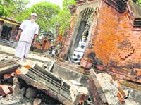 A Bali resident looks at debris from a damaged temple in Denpasar following a powerful earthquake that jolted the resort island of Bali on Thursday. 