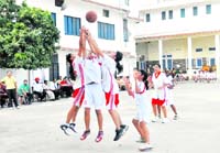 Players vie for the ball in the district basketball championship in Dehradun on Friday.