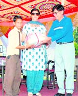 A student is awarded the Shri Mela Ram Marwah Memorial Scholarship by the president of the Shri Guru Nanak Public Boys Inter-college Managing Committee in Dehradun on Friday. 