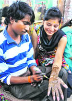 A woman gets mehndi applied to her hand ahead of Karva Chauth at Patel Market in Jammu. 
