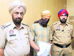 Detained drug peddler Manjinder Singh flanked by two policemen in Jalandhar on Friday