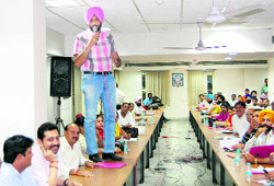 Opposition councillor Nirmal Singh Nimma stands on the desk to make his point during a meeting of the MC House in Jalandhar on Friday