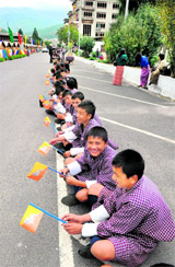 Bhutanese students cheer as they wait to welcome King Jigme Khesar Namgyel Wangchuk and Queen Jetsun Pema in Thimphu on Friday.