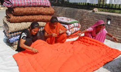 Women busy stitching quilts near Dhobi Ghat area in Bathinda. 