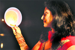 A woman sees the moon through a mesh on the occasion of Karva Chauth at the Sukhna Lake in Chandigarh on Saturday