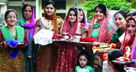 Women participate in Karva Chauth Katha in New Delhi on Saturday.