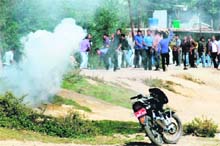 Protesters throw stones at the police amid heavy tear smoke during an anti-encroachment drive being conducted in the vicinity of the Dal Lake in Srinagar on Saturday. 
