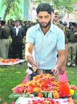 The brother of the slain constable lays a wreath on his body.