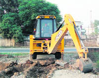A JCB machine of the Greater Ludhiana Area Development Authority (GLADA) demolishes an illegal colony in Ludhiana on Friday evening