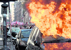 A car is set on fire as activists protesting against corporate greed and austerity measures clashed with the police in Rome on Saturday