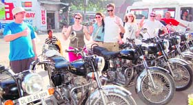 Eight members of Britain-based Global Adventure Challenges pose for a picture along with Royal Enfield 1950s style motorbikes