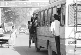 Passengers hang on to a Haryana Roadways bus near Majri Chowk in Panchkula, risking their lives.