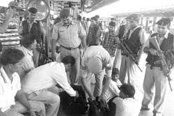 A policeman checks a bag of a passenger at the Ambala railway station.