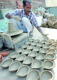 A potter at Paharganj in New Delhi prepares diyas for Divali. 