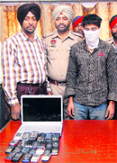 The accused in police custody with the mobile phones recovered from him.