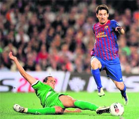 Barcelona's Lionel Messi (R) vies with Racing Santander's Bernardo Espinosa during the Spanish League match at Camp Nou in Barcelona on Saturday