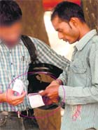 A black marketeer sells a ticket of the India-England ODI to a cricket fan near a ticket counter at the PCA Stadium in Mohali on Monday.