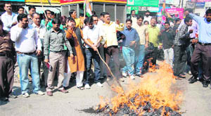 Congress workers burn an effigy of the government at the Clock Tower in Dehradun on Monday. 