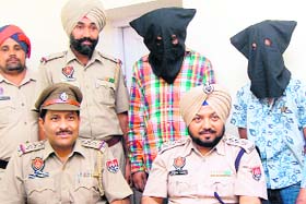 The arrested snatchers (faces covered) with police officials in Jalandhar