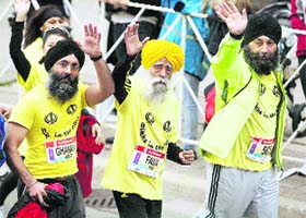Fauja Singh (centre) waves to onlookers at the Scotia Bank Toronto Marathon on Sunday