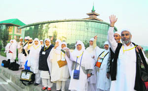 Kashmiri pilgrims wave as they depart for Mecca for the annual Haj pilgrimage, in Srinagar on Monday. 