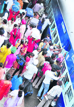 Labourers flock at the Ludhiana Railway Station to board a train. 