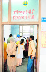 Patients surround a doctors table at an OPD.