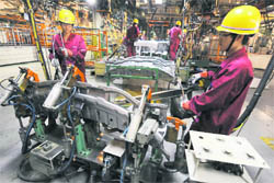 Employees weld cars at Anhui Jianghuai Automobile Co Ltd (JAC Motors) plant in Hefei, Anhui province, on Tuesday. China's economic expansion slowed in the third quarter to its weakest pace since early 2009, but core domestic drivers of growth remained robust, suggesting little chance monetary policy can be relaxed in the near term. 