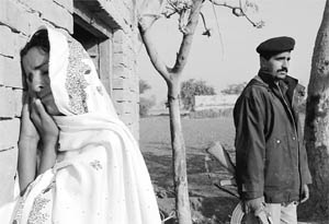 Mukhtar Mai, with a police constable appointed for her safety, at her home in Multan