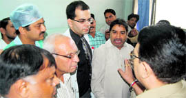 Family members of Satya Devi discuss the issue with a police official in a hospital in Jalandhar on Tuesday.